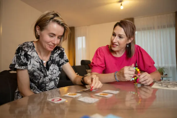 Doelgroep autisme, Amarant, cliënt speelt spel aan tafel met zorgprofessional