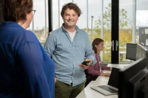 medewerker op kantoor samen met collega's amarant