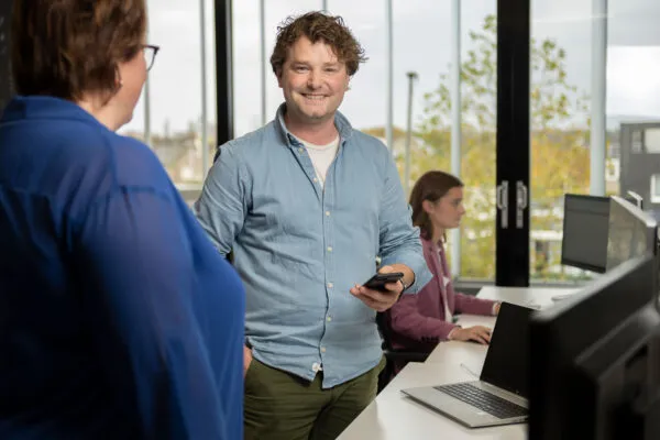 medewerker op kantoor samen met collega's amarant