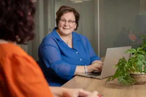 Medewerker met collega samen achter de laptop.