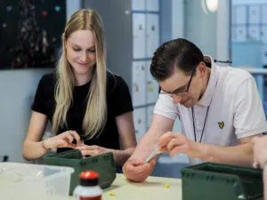 Doelgroep autisme, Amarant, cliënt werkt aan tafel met zorgprofessional