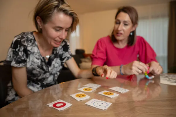 zorgprofessional speelt spel met cliënt met autisme